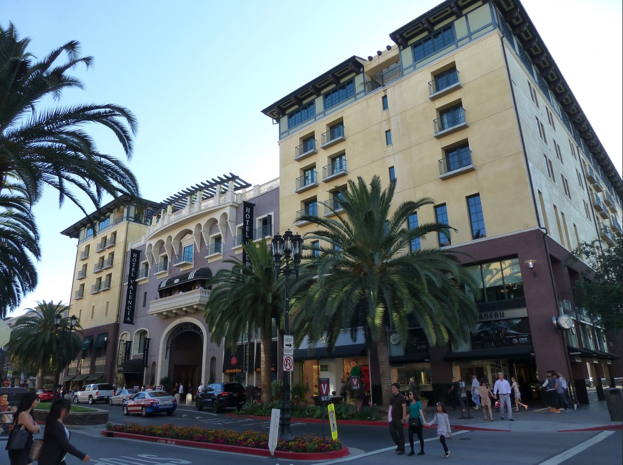 Photo of buildings and people including the hotel valencia in downtown San Jose.