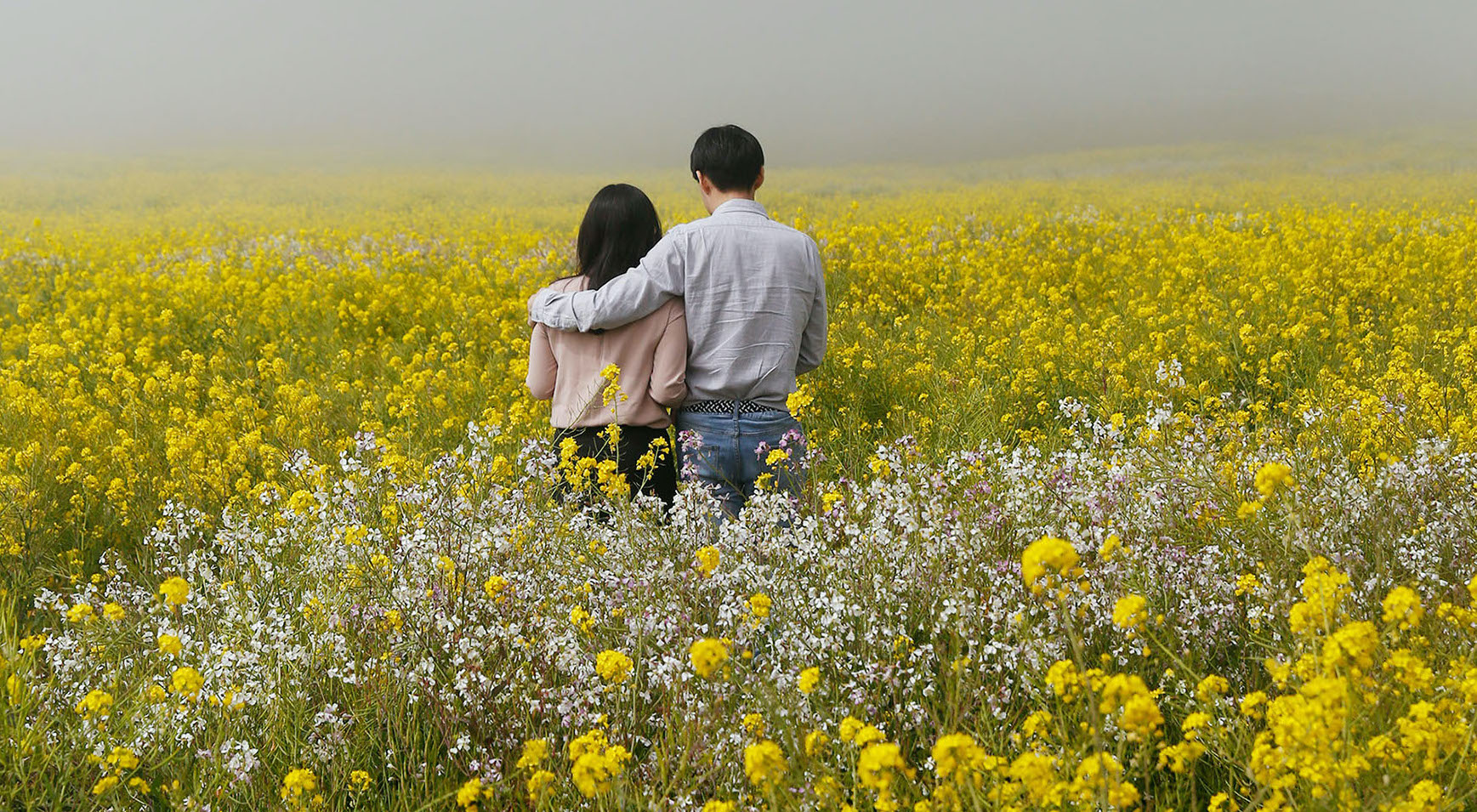 couple in field of wildflowers post drought