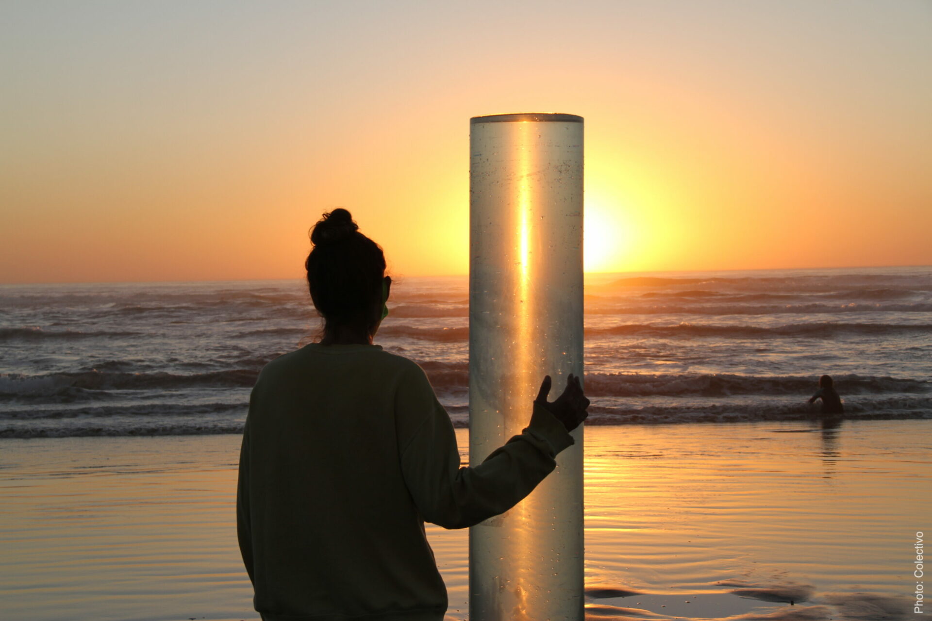 woman standing looking at sunset on beach
