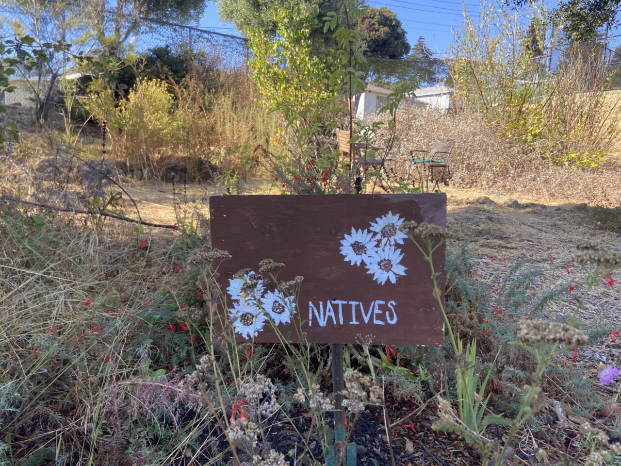 A sign in front of a garden