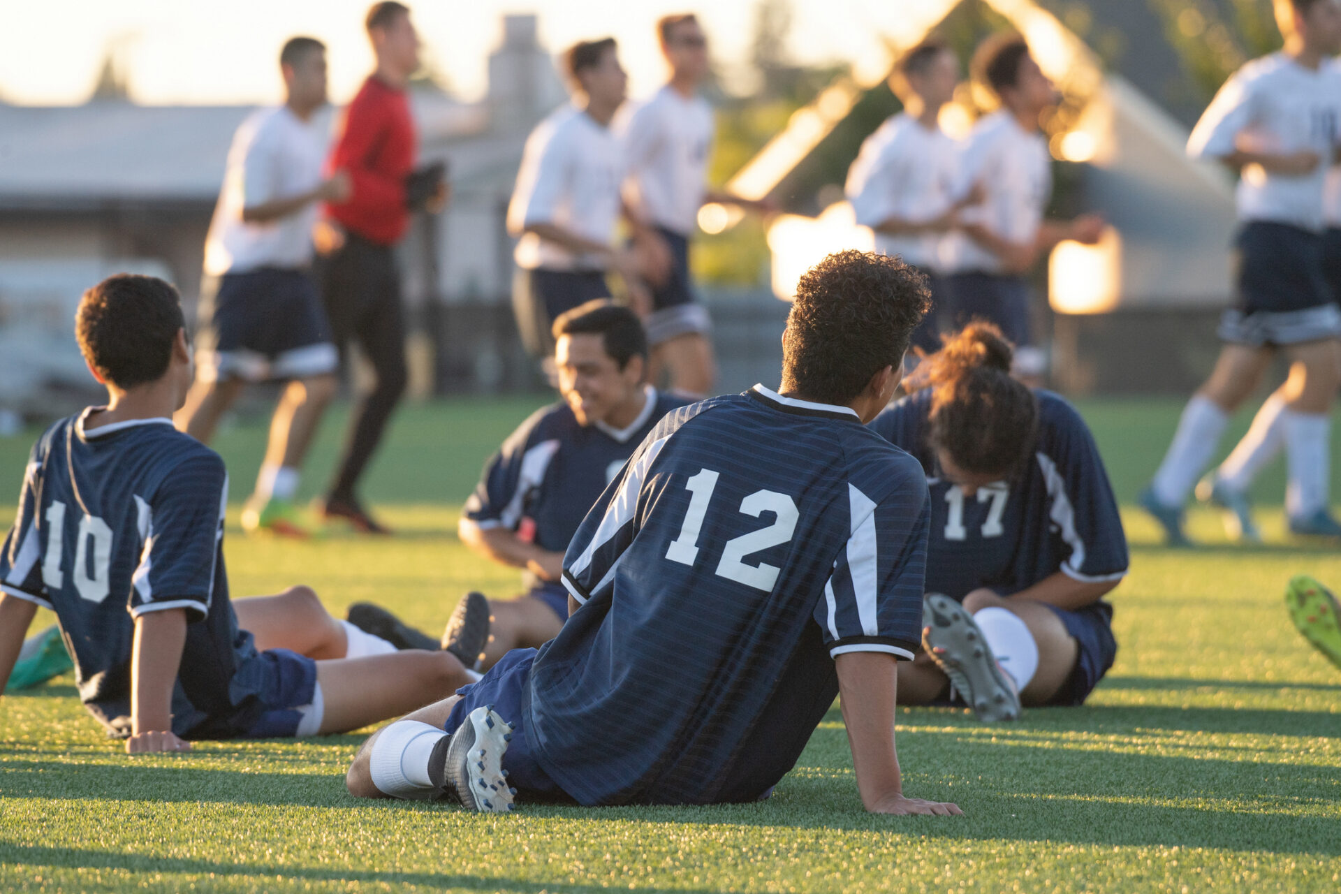 Four soccer players stretching out before a match.