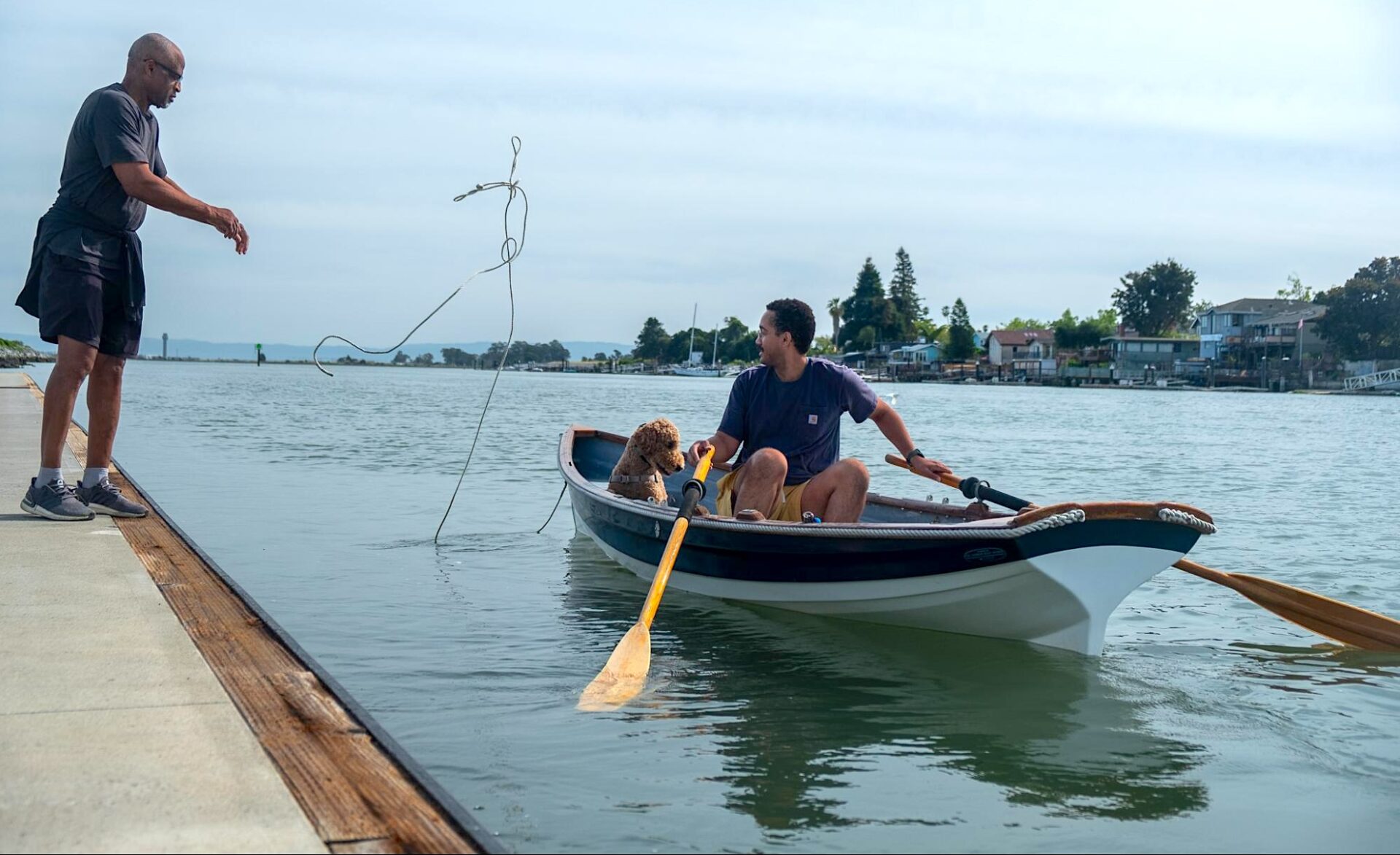 A man and dog in paddle boat. 