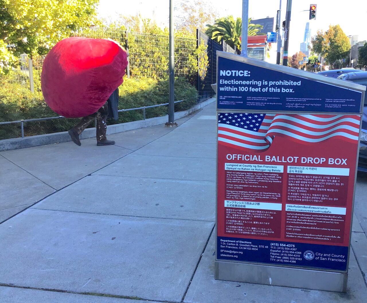 homeless person walks next to ballot box